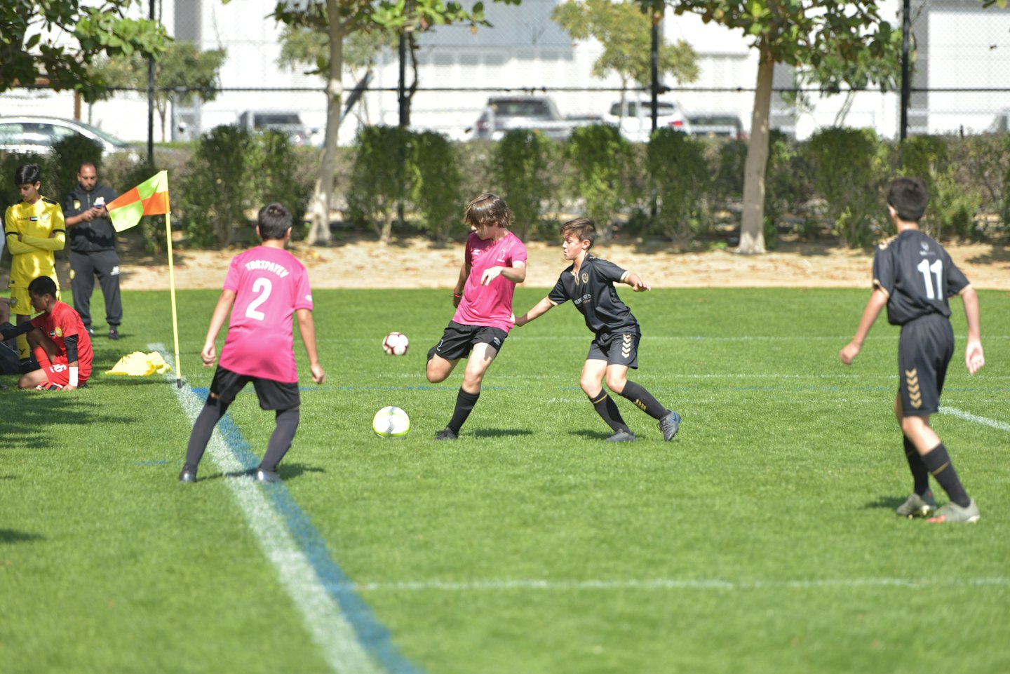 Ragazzi giocano a calcio su un prato verde brillante.